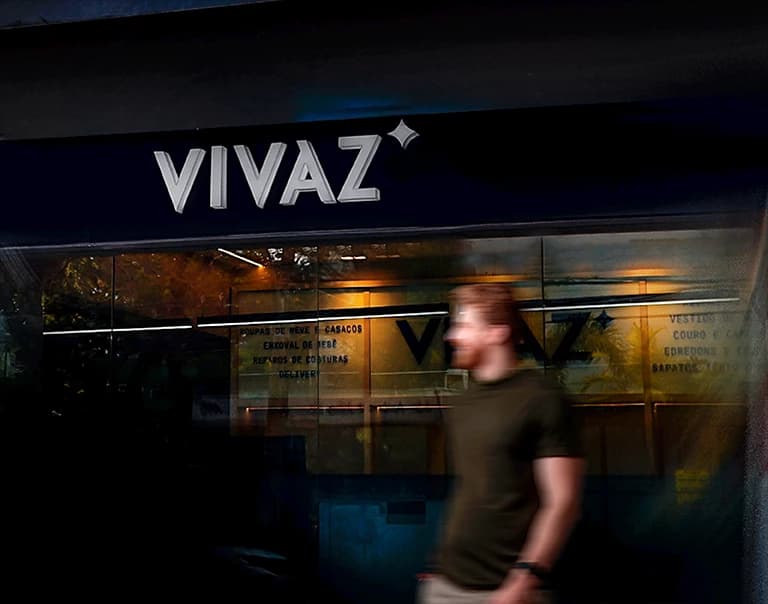 Fachada noturna da Vivaz Lavanderia em Recife, com tipografia clean iluminada e ambiente premium